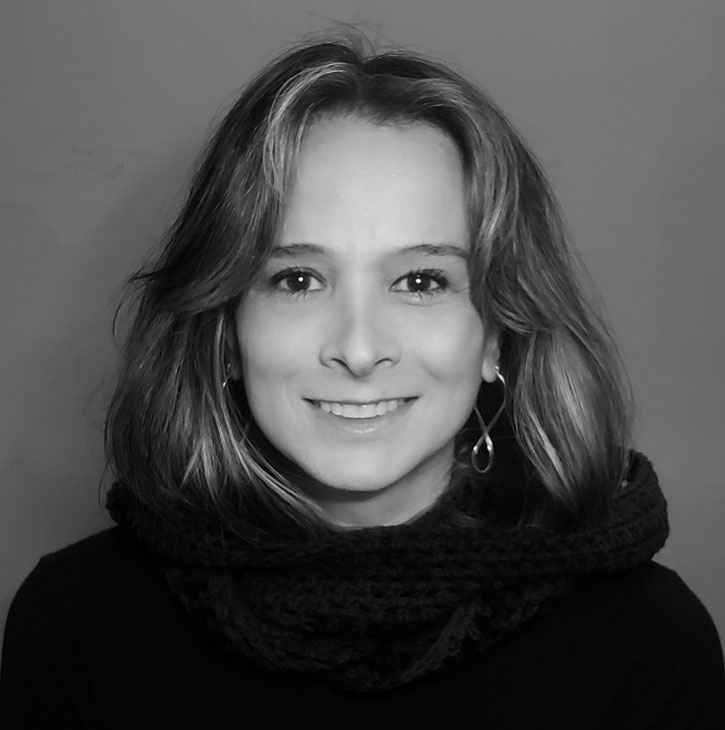 Fotografia em preto e branco de Carolina Ursi.Ela está olhando para frente e sorrindo